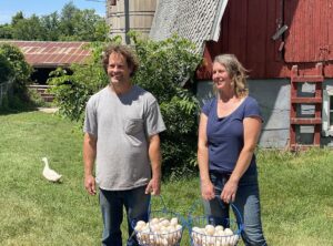 Farmers Andy and Tiffany Hold Baskets of Duck Eggs